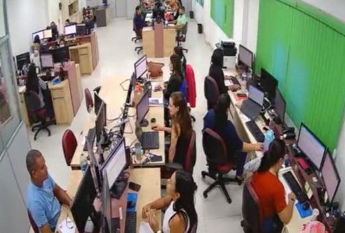 Espaço físico moderno do CSC com equipe trabalhando em estações